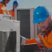 Worker studying air conditioner unit