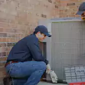 Workers fixing air conditioner unit