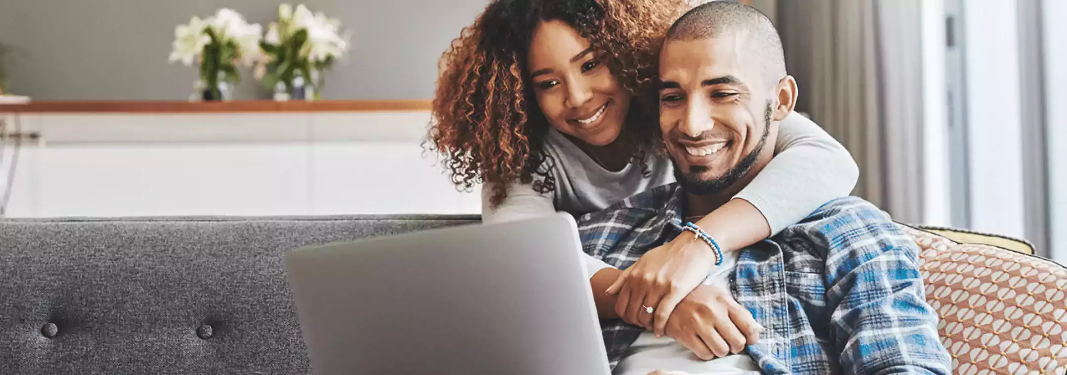 couple smiling looking at laptop